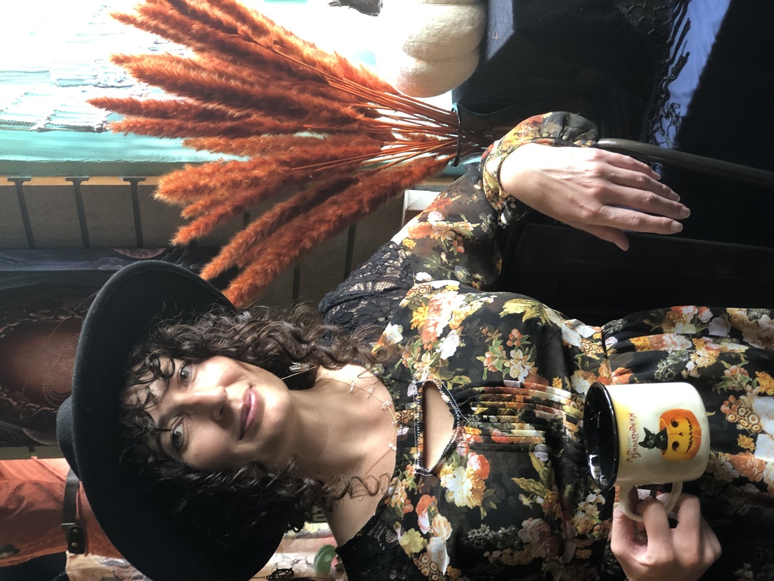 Nicolina holding a Halloween-themed cup at Go Ask Alice